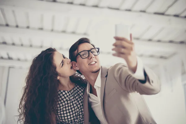 Casal tirando uma foto com seu telefone celular enquanto — Fotografia de Stock