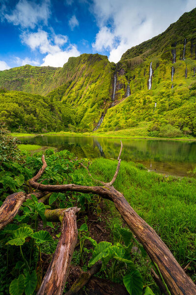Azores scenic landscape, Flores island. Iconic lagoon with over 20 separate waterfalls on a single rockface, flowing into lake Alagoinha. Best travel destination in Portugal, amazing vacations place.