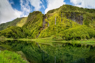 Azores scenic landscape, Flores island. Iconic lagoon with over 20 separate waterfalls on a single rockface, flowing into lake Alagoinha. Best travel destination in Portugal, amazing vacations place. clipart