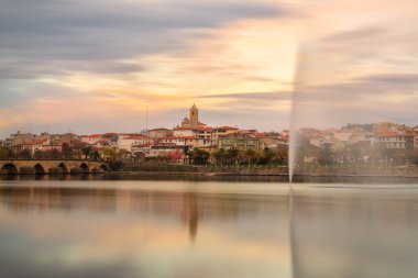 Portekiz 'in kuzeyindeki Mirandela kentinin kent manzarası. Geleneksel Roma köprüsü ile Tua nehrinin panoramik manzarası ve kilise kulesi ile tarihi merkez..