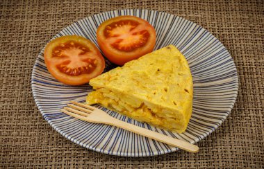Seramik tabakta taze domatesli İspanyol patates omleti.