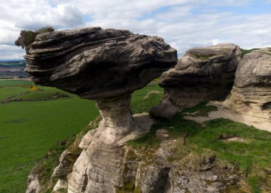 The Bunnet Stane is a rock formation near the hamlet of Gateside in Fife, at the foot of West Lomond. It sits upon one of the calciferous sandstone outcrops of the Old Red Sandstone suie that exist around the base of the Lomond Hills. Scotland. U.K. clipart