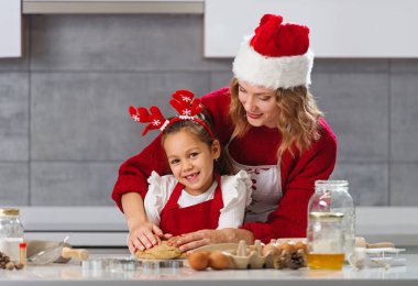 Anne ve kız mutfakta Noel kurabiyesi yapıyorlar. 