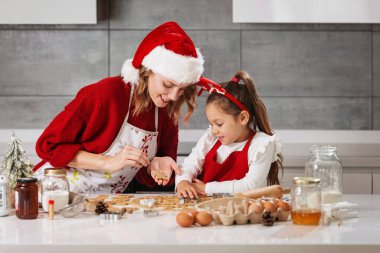 Anne ve kız mutfakta Noel kurabiyesi yapıyorlar. 