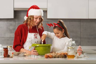 Anne ve kız mutfakta Noel kurabiyesi yapıyorlar. 