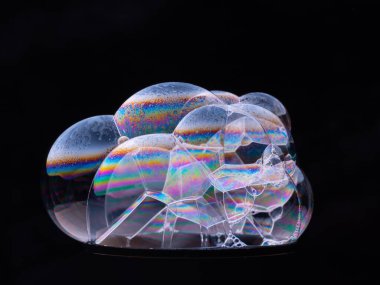 Sabun köpüklerini siyah arkaplanda kapat. Yanlarda gökkuşağı gradyanı. Makro çekim