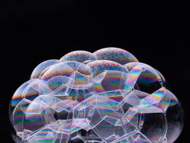 Siyah arka planda izole edilmiş gökkuşağı renginde köpük baloncukları. Makro çekim.