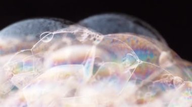 Sabun köpüğü baloncukları siyah arkaplanı kapatır. Makro atış. Gökkuşağı gradyanı. Yumuşak odaklanma. Bulanık arkaplan.