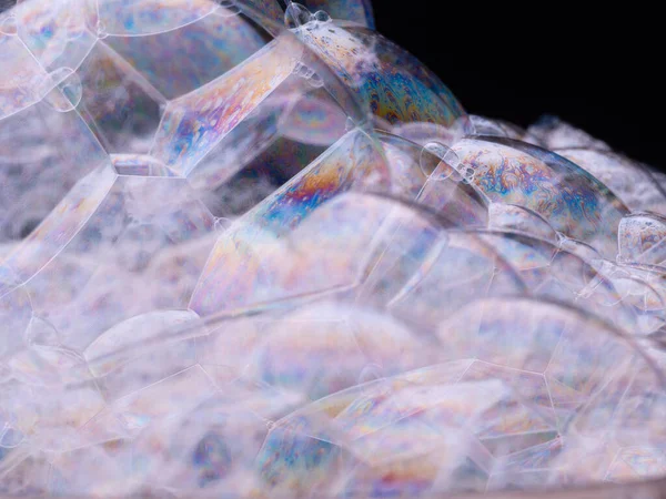 虹石鹸泡を閉じる。抽象的なパターン。黒い背景に石鹸泡のマクロショット. — ストック写真