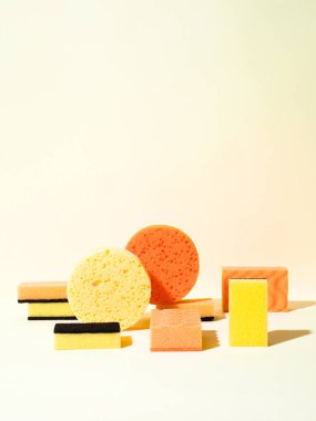 Farklı şekillerde köpük plastik süngerlerle soyut kompozisyon. Yuvarlak ve dikdörtgen şekiller. Sarı ve turuncu renkler. Temizlik kavramı.