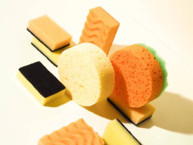 Kauçuk süngerli kompozisyon. Bir açıdan çek. Sarı arka plan. Soyut model. Farklı süngerler. Sert gölge biçimi.