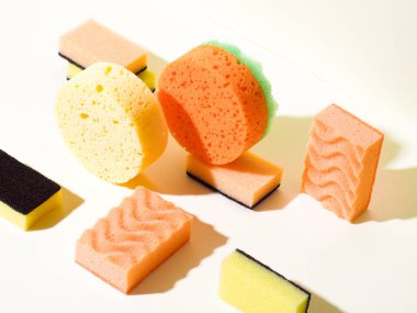 Sarı arka planda farklı şekillerde süngerler. Geometrik bileşime yukarıdan aşağıya açı görünümü. Analog renk şeması.