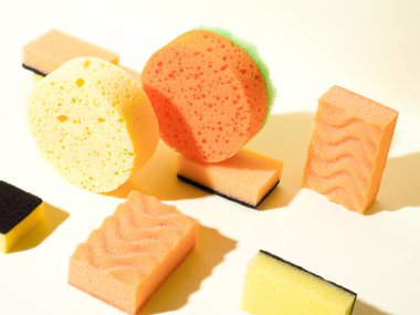 Geometrik bileşime yukarıdan aşağıya açı görünümü. Farklı şekillerde sünger süngerler. Yuvarlak ve dikdörtgen şekiller. Sarı ve turuncu renkler.