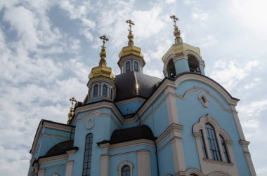 Mavi arka planda haçları olan Hristiyan kilisesinin altın kubbeleri.
