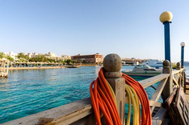 Kızıl denizin arka planında plaj şemsiyeleri ve palmiye ağaçları ve Mısır hurghada 'da gemiler.