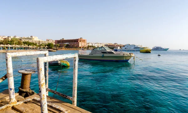 Kızıl denizin arka planında plaj şemsiyeleri ve palmiye ağaçları ve Mısır hurghada 'da gemiler.
