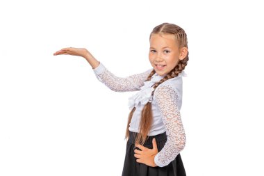 Beyaz bluzlu, örgülü bir kız öğrenci elini gösteriyor. Okul üniformalı bir kız. Stüdyo fotoğrafı, beyaz arka planda izole edilmiş. eğitim