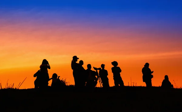 Turisti silhouette e fotografi con bella alba su — Foto Stock