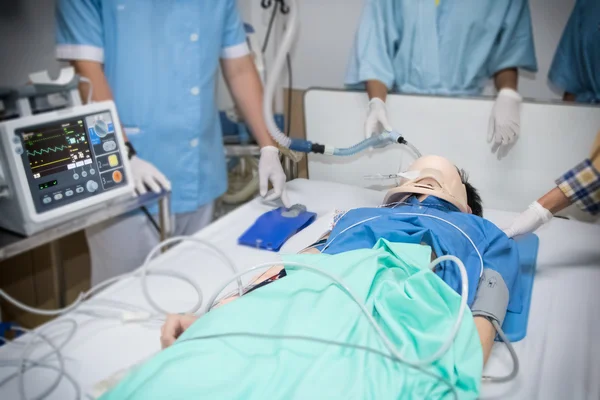 Arts en de verpleegsters behandelen kritieke mannelijke patiënt in noodgevallen ro — Stockfoto