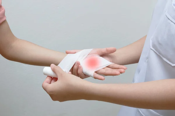 Krankenschwester legt Verband an verletzte Hand des Patienten — Stockfoto
