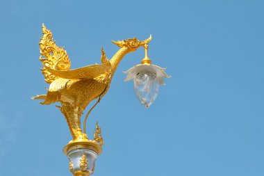 Tapınakta altın kuğu heykelleri ile elektrikli ışık direği
