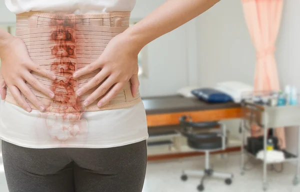 Mujer con dolor de espalda por lesión medular con corsé lumbar —  Fotos de Stock