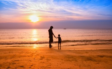 Baba ve oğul oynamak sahilde sunrise siluet atış