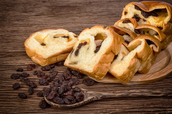 Sliced of bread with raisins on wooden background — Stock Photo, Image