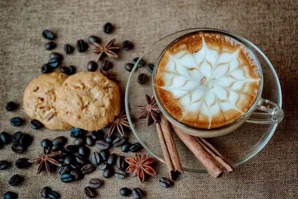 Ένα φλιτζάνι καφέ latte με κόκκους καφέ και μπισκότα — Φωτογραφία Αρχείου