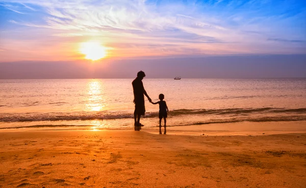 Father and son play on the Beach in sunrise silhouette shot — Stock Photo, Image