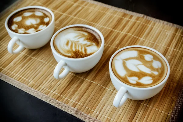 Três xícaras de café 'latte com três formas de arte latte — Fotografia de Stock