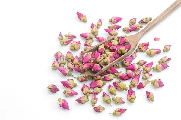 Roses flowers tea in a wooden scoop on a white background. — Stock Photo, Image