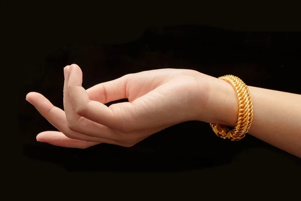 Ženská ruka drží zlatý náramek šperky izolovat na černé izolátu — Stock fotografie