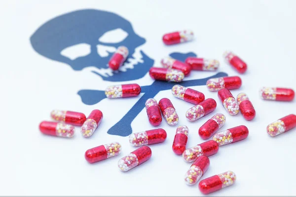 Pillole mediche versando sul cranio segno di pericolo — Foto Stock