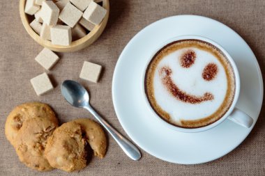 Latte sanat mutlu gülümseme yüzünü üstten görünüm beyaz fincan 