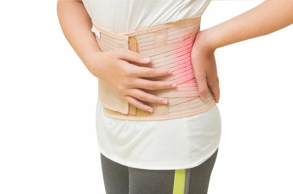 Woman in pain from back injury wearing lumbar brace corset — Stock Photo, Image