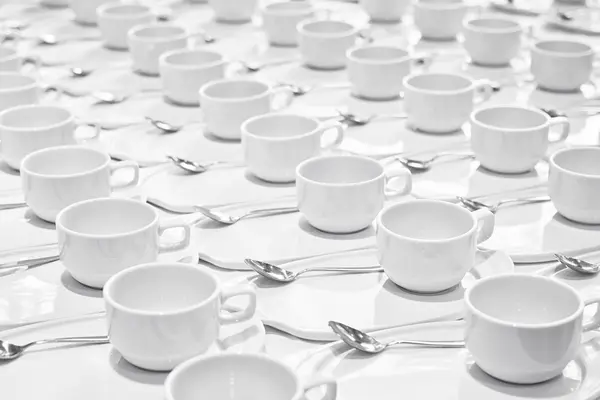 Montones de tazas de café con cucharaditas de plata se preparan para la meetina —  Fotos de Stock