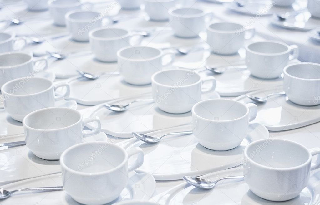 Stacks of coffee cups  with silver teaspoons  prepare for meetin