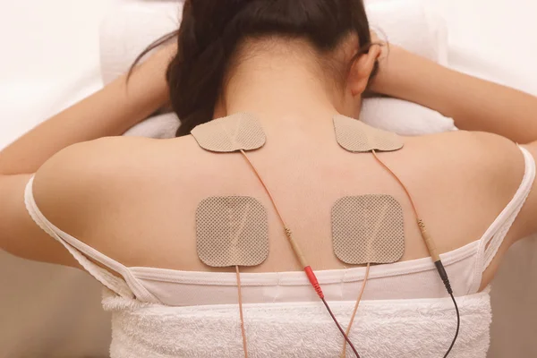 Mujer asiática está haciendo masaje de estimulación eléctrica (TENs  ) — Foto de Stock