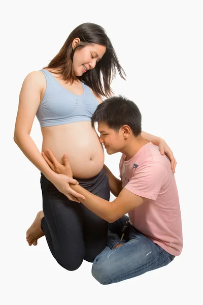 Homem feliz beijando barriga grávida de sua esposa — Fotografia de Stock