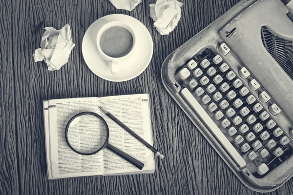 Το λεξικό εξετάσει κάτω από ένα μεγεθυντικό φακό πάνω στο γραφείο του συγγραφέα με — Φωτογραφία Αρχείου