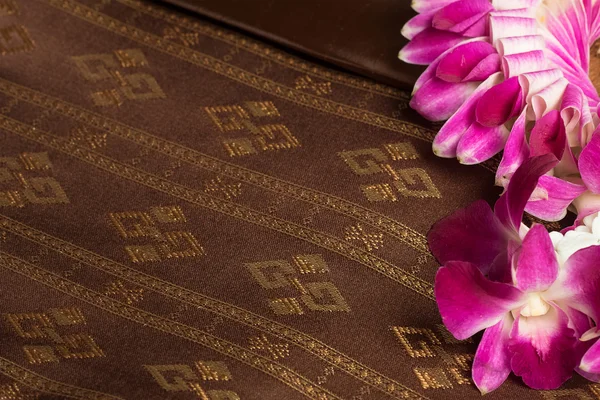Traditional brown Thai fabric pattern with orchid garland — Stock Photo, Image