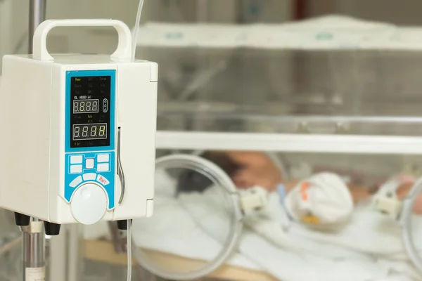 Infusion pump feeding IV drip into baby's patients — Stock Photo, Image