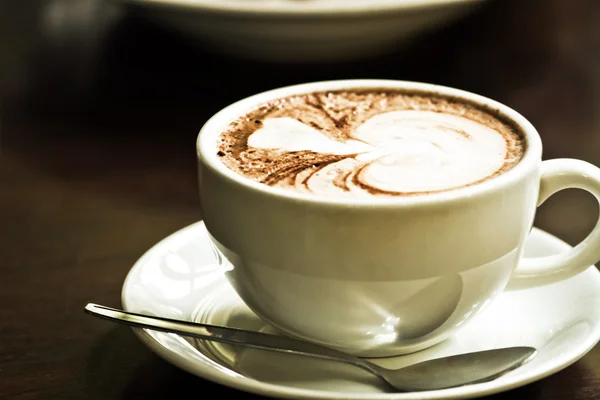 Cappuccino dalam cangkir putih di piring putih — Stok Foto