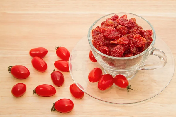 Tomates secos em vidro sobre fundo de madeira — Fotografia de Stock