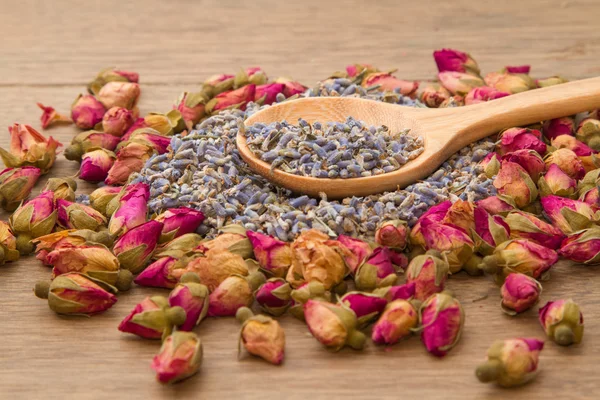 Lavanda seca y té de flor de rosa en cuchara de madera —  Fotos de Stock