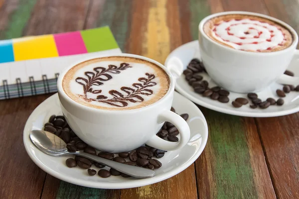 Kaffee-Latte-Kunst auf dem Holztisch — Stockfoto