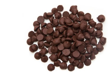 Beyaz zemin üzerine tahta kaşık çikolata parçaları