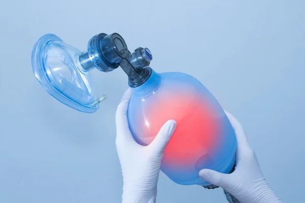 Doctor's hand hold breathing bag on blue background — Stock Photo, Image