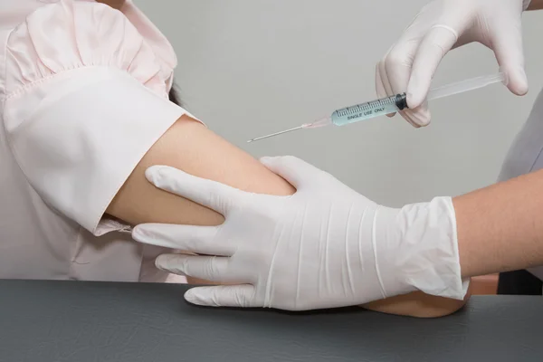 Mulher está a ser injectada com uma seringa no hospital — Fotografia de Stock